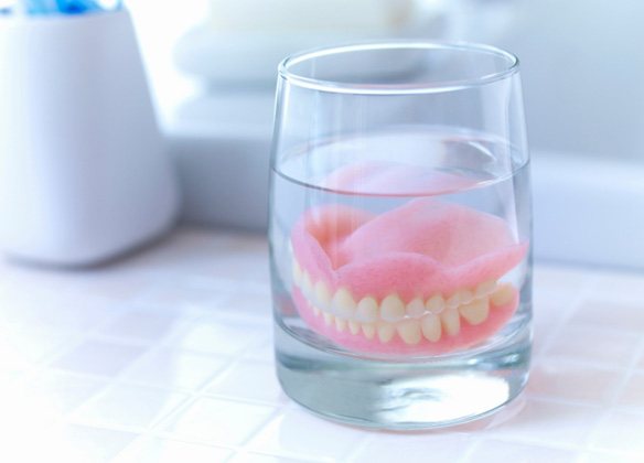 dentures sitting in a glass of water