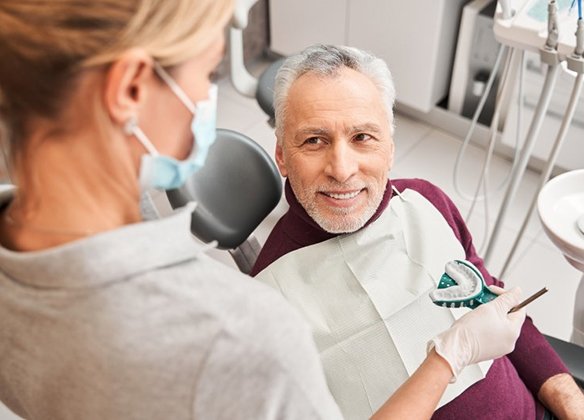 Older man smiling at his dentist