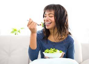 Woman eating a salad and smiling