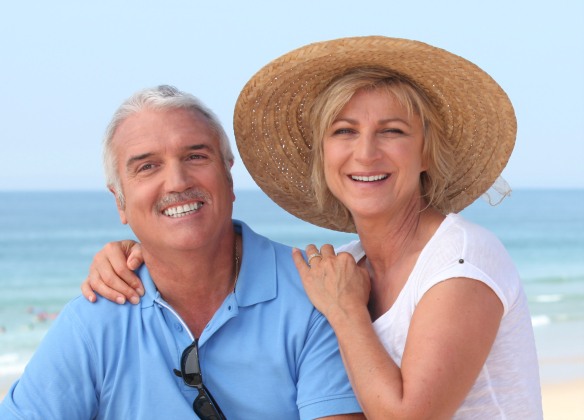 Older man and woman smiling on beach