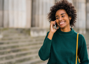 Woman in green shirt walking and talking on cell phone