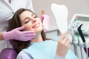 Young woman looking at herself in the mirror at the dentist's office.